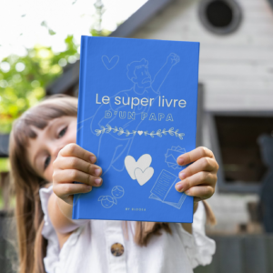 L'enfant tient le livre de souvenirs de son papa, rempli de moments précieux et de conseils